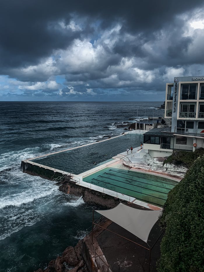 Majestic view of Bondi Icebergs Pool against the moody ocean and sky backdrop.